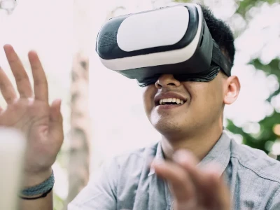 gros plan d'un jeune homme souriant et portant un casque de réalité virtuelle