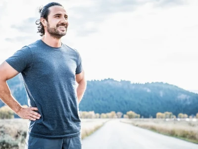 Coureur se reposant après avoir fait de l'exercice dans la campagne près des montagnes