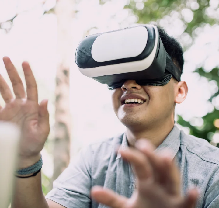 gros plan d'un jeune homme souriant et portant un casque de réalité virtuelle