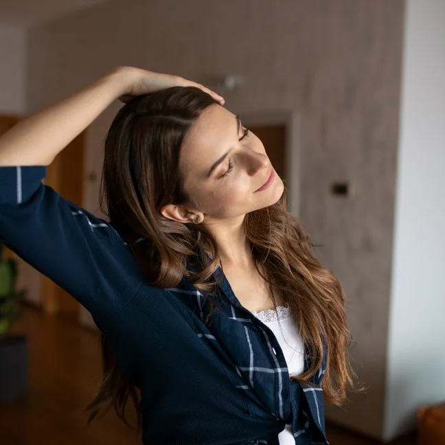Jeune femme étirant son cou avec son bras droit